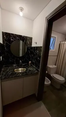 a bathroom with a sink and a toilet and a mirror at Departamento Premium en el corazón de Villa Carlos Paz in Villa Carlos Paz