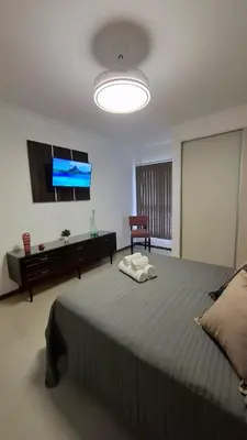 a bedroom with a large bed and a flat screen tv at Departamento Premium en el corazón de Villa Carlos Paz in Villa Carlos Paz
