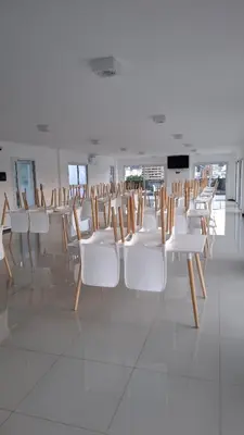 a row of white chairs in a room at Departamento Premium en el corazón de Villa Carlos Paz in Villa Carlos Paz
