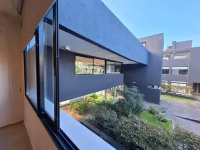 an external view of a building with a large window at Dpto Premium Frente al lago in Villa Carlos Paz