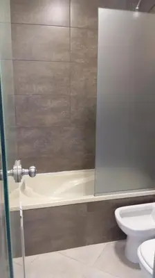 a bathroom with a bath tub and a toilet at Dpto Premium Frente al lago in Villa Carlos Paz