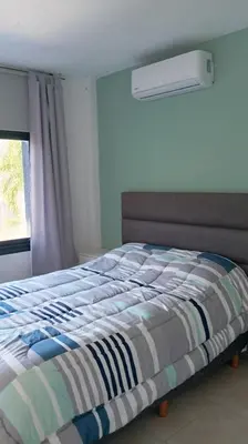 a bed with a striped comforter in a bedroom at Dpto Premium Frente al lago in Villa Carlos Paz