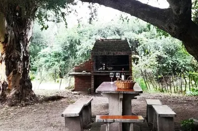 a picnic table and benches in front of a building at Paraiso Cabañas in La Ramada