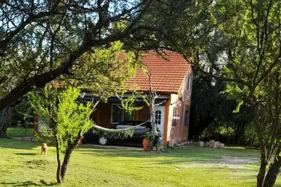 a house with a hammock in front of it at Paraiso Cabañas in La Ramada