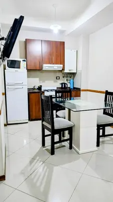a kitchen with a table and chairs and a refrigerator at Departamento en el Centro Completo, Cochera, Pile, Pile Clim in Villa Carlos Paz