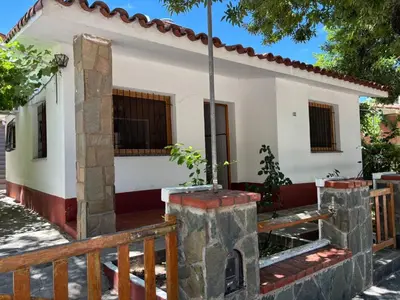 a small white house with a wooden fence at Paraíso in Mina Clavero