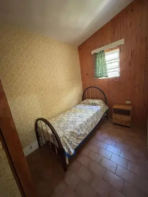a small bedroom with a bed and a window at Paraíso in Mina Clavero