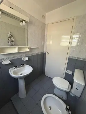 a bathroom with a sink and a toilet and a mirror at Paraíso in Mina Clavero