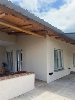 a patio with a wooden roof on a house at Cabaña hasta siete personas Complejo Aires de montaña siquiman in Villa Parque Siquiman