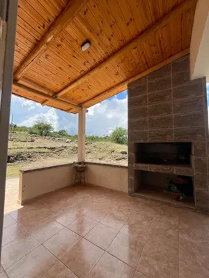 a living room with a fireplace and a wooden ceiling at Cabaña hasta siete personas Complejo Aires de montaña siquiman in Villa Parque Siquiman