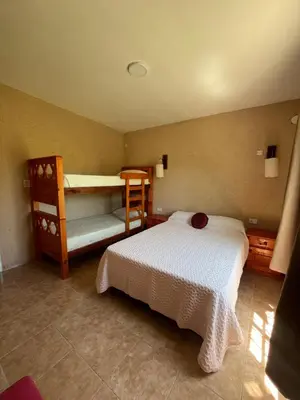 a bedroom with a bed and two bunk beds at Cabaña hasta siete personas Complejo Aires de montaña siquiman in Villa Parque Siquiman