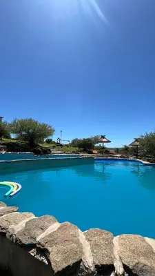 a large pool of blue water next to some rocks at Cabaña hasta siete personas Complejo Aires de montaña siquiman in Villa Parque Siquiman