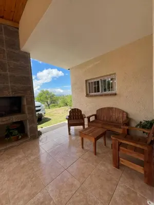 a living room with two benches and a fireplace at Cabaña hasta siete personas Complejo Aires de montaña siquiman in Villa Parque Siquiman