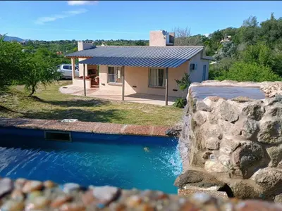 a house with a swimming pool in front of it at Cabaña hasta siete personas Complejo Aires de montaña siquiman in Villa Parque Siquiman
