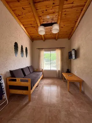 a living room with a couch and a table at Cabaña hasta siete personas Complejo Aires de montaña siquiman in Villa Parque Siquiman
