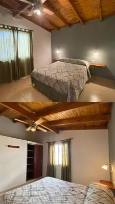 two beds in a bedroom with wooden ceilings at Complejo de cabañas El Nido in Mina Clavero