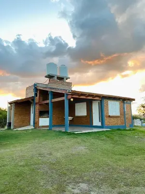 a house with two wind turbines on top of it at Complejo de cabañas El Nido in Mina Clavero
