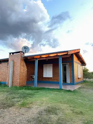 a brick house with a satellite on top of it at Complejo de cabañas El Nido in Mina Clavero