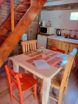 a kitchen with a table and chairs in a kitchen at Cabañas El Nirvana Villa Quillinzo in Villa Quillinzo