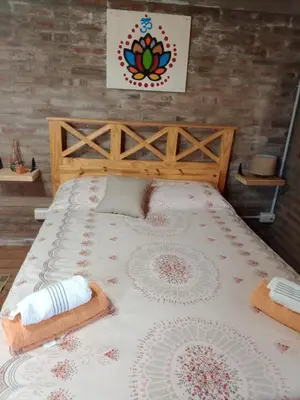 a large bed with two pillows on top of it at Cabañas El Nirvana Villa Quillinzo in Villa Quillinzo
