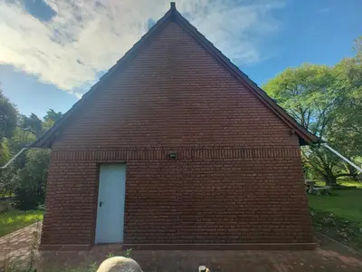 a red brick building with a white door at Chalet Noemí in Villa Ciudad de America