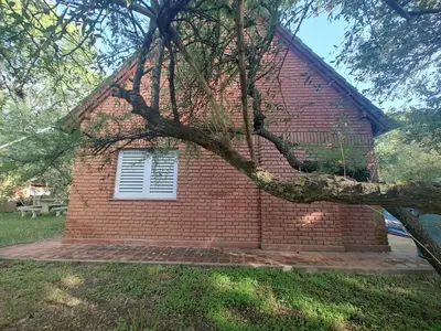 a brick building with a window and a tree at Chalet Noemí in Villa Ciudad de America