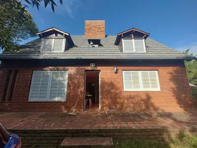 a brick house with two windows and a door at Chalet Noemí in Villa Ciudad de America