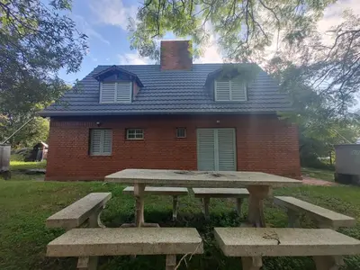 a house with a picnic table in front of it at Chalet Noemí in Villa Ciudad de America
