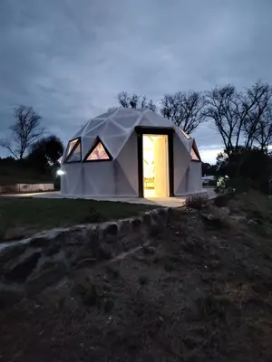 a tent with a door in a field at night at Domo Bike in Villa Ciudad de America
