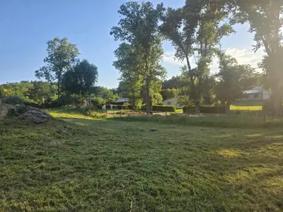 a field with trees and a house in the background at Domo Bike in Villa Ciudad de America