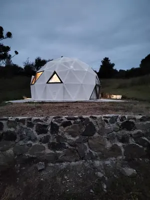 a large white tent sitting on top of a field at Domo Bike in Villa Ciudad de America