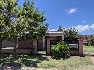 a brick house with a tree in front of it at Casa El Buen Descanso Cura Brochero in Villa Cura Brochero