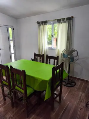 a dining room with a green table and chairs at Casa El Buen Descanso Cura Brochero in Villa Cura Brochero