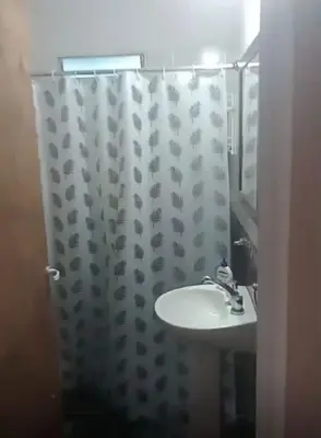 a bathroom with a sink and a shower curtain at El Tito Alojamiento in San Roque