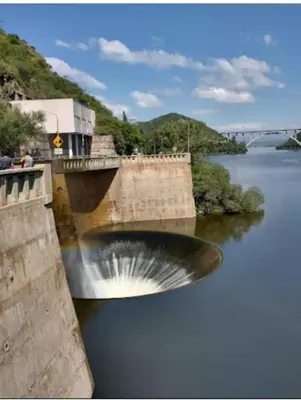 a bridge over a river with a waterfall at El Tito Alojamiento in San Roque