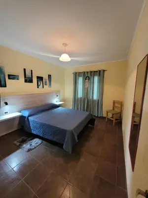a bedroom with a blue bed and a chair at Balcones de Bialet in Bialet Massé
