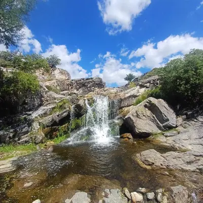 a waterfall in the middle of a pool of water at Las huertitas de Milele