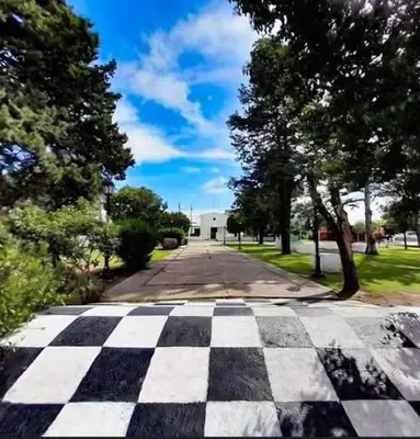 an empty street with a checkerboard patterned sidewalk at Las huertitas de Milele