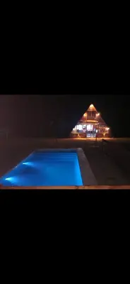 a swimming pool in front of a house at night at Las huertitas de Milele