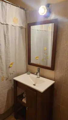 a bathroom with a sink and a mirror and a shower at Casa Céntrica a 4c del rio de 2 Dormitorios para 5 in Villa Carlos Paz