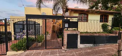 a house with a black gate and a fence at Casa Céntrica a 4c del rio de 2 Dormitorios para 5 in Villa Carlos Paz