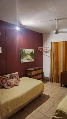 a bedroom with a bed and a painting on the wall at Casa Céntrica a 4c del rio de 2 Dormitorios para 5 in Villa Carlos Paz