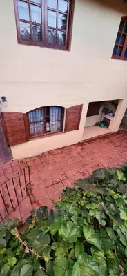 a building with a bunch of plants in a yard at Casa Céntrica a 4c del rio de 2 Dormitorios para 5 in Villa Carlos Paz