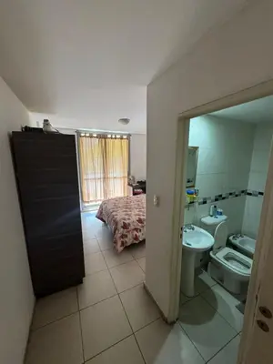 a bathroom with a sink and a toilet and a bed at El cercano a todo in Cordoba