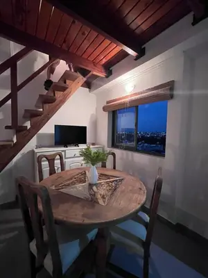 a dining room with a wooden table and a window at Depto mini penthouse in Cordoba