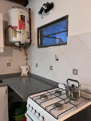 a kitchen counter with a stove and a window at Depto mini penthouse in Cordoba