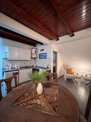 a kitchen and dining room with a wooden table at Depto mini penthouse in Cordoba