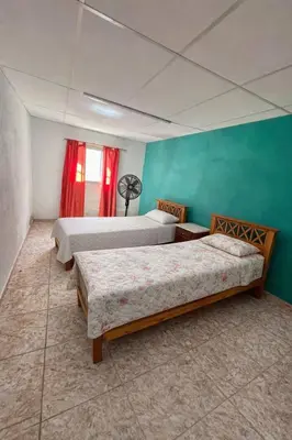 a bedroom with three beds and a green wall at Casa El Trapiche Lo Altos in Trapiche