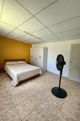 a bedroom with a bed and a fan on the floor at Casa El Trapiche Lo Altos in Trapiche