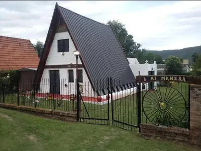 a small white church with a black roof at Cabaña A Mí Manera in Villa Carlos Paz
